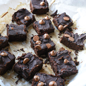 Black bean brownie spread out on parchment paper and sprinkled with chocolate chips