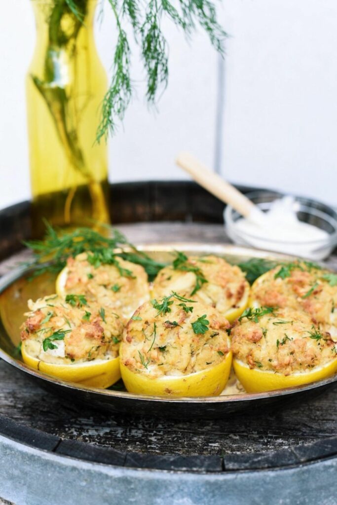 Six crab cake stuffed lemons on an old whisky barrel