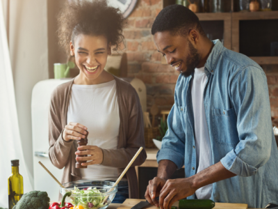 A couple in the kitchen laughing and learning tips to make home cooking easier and better