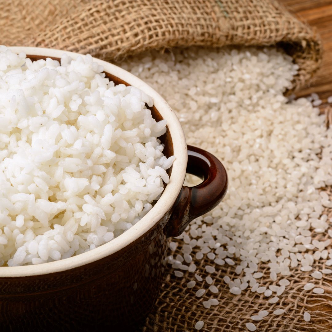 Cooked white rice in a brown pot.