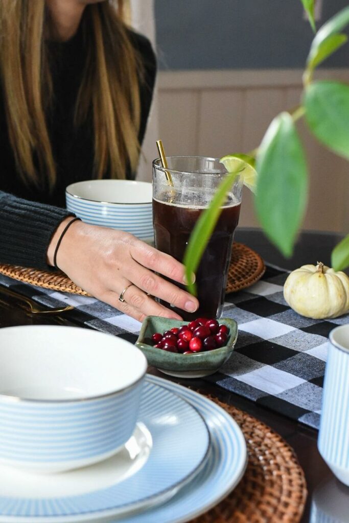 A hand grabbing a large glass filled with espresso lime coffee tonic recipe