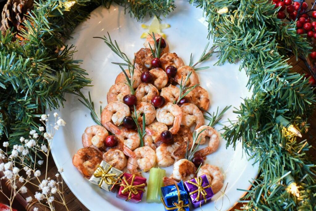 A white platter filled with a shrimp christmas tree.