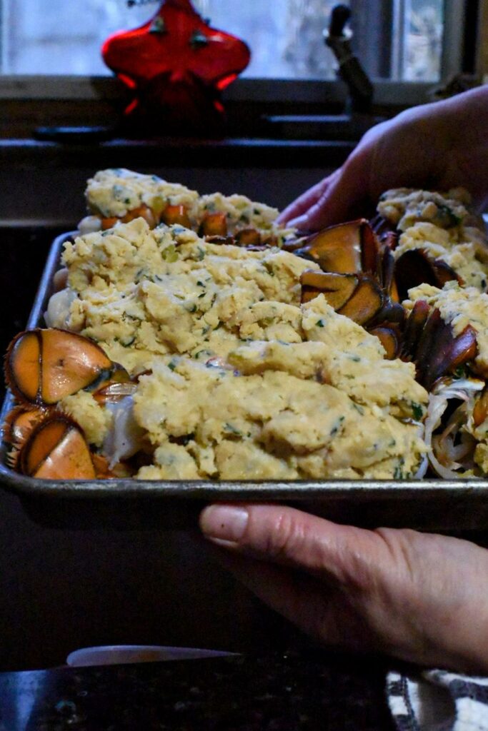 Stuffed lobster tails raw on a baking sheet