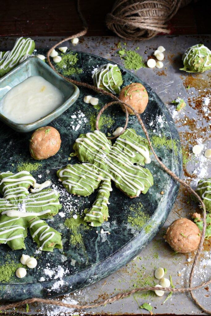 A blue marble serving plate topped with green shamrock cookies drizzled with white chocolate