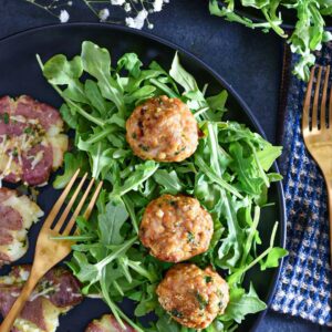 chipotle chicken meatballs on a black plate with salad