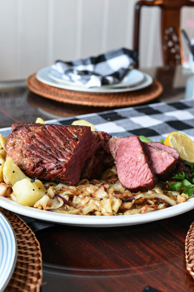 sliced corned beef on top of lemon cabbage and potatoes.