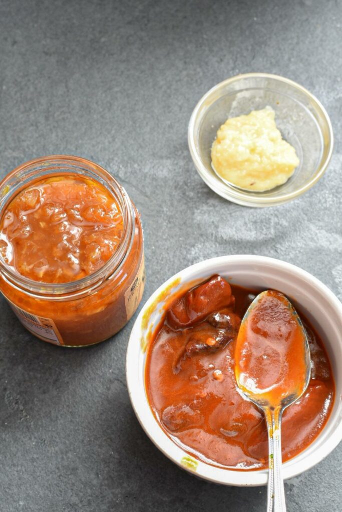 Three separate bowls filled with chipotles in adobo sauce, ginger paste and orange jam