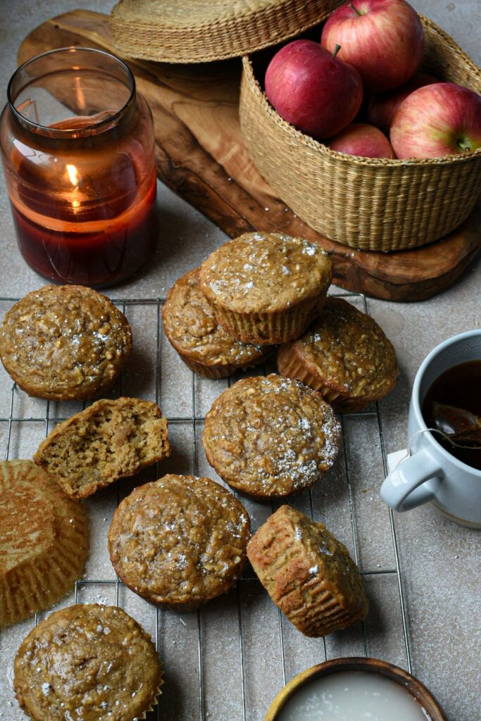 An overhead shot of easy apple muffins on a cooling rack with tea and a basket of apples in the shot.