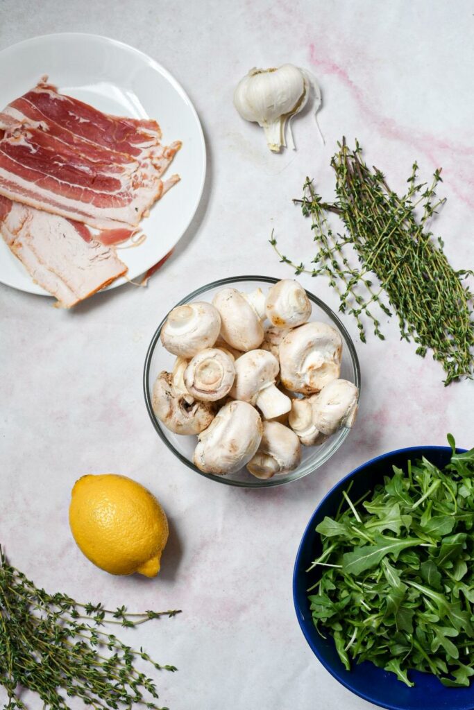 The ingredients to make bacon sauteed baby bella mushrooms