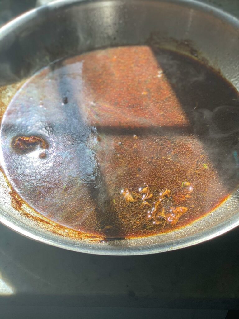A skillet that was deglazed and now has a brown chicken pan sauce.