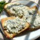a gold rimmed appetizer plate with three triangular slices of baked crispy pita bread, topped with feta and greek yogurt.