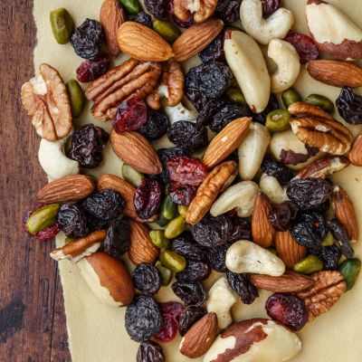 A variety of mixed nuts on parchment paper over a wooden table