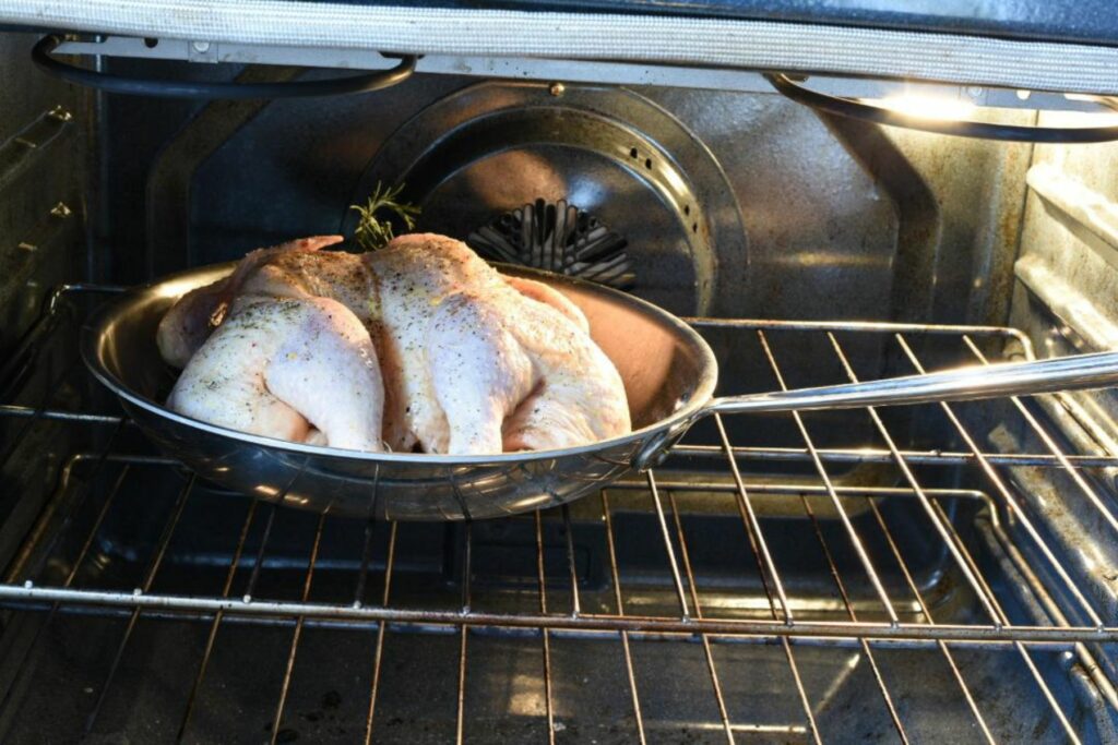 whole raw chicken in a skillet in the oven to bake