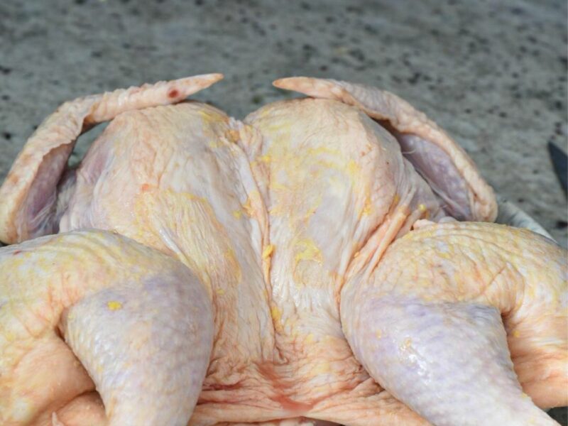 spatchcock chicken A spatchcocked chicken laying flat on a plate