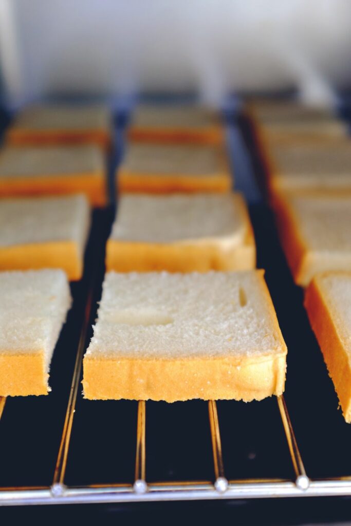 A few rows of bread cut into small squares on in an indoor grill