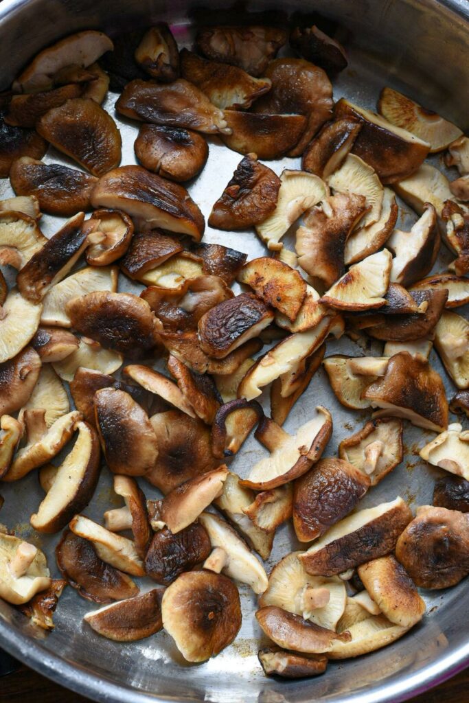 Sauteed shiitake mushrooms in a stainless steel pan