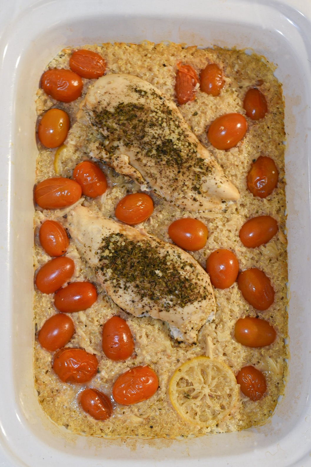 Overhead shot of slow cooker lemon chicken and quinoa with cherry tomatoes and garlic.