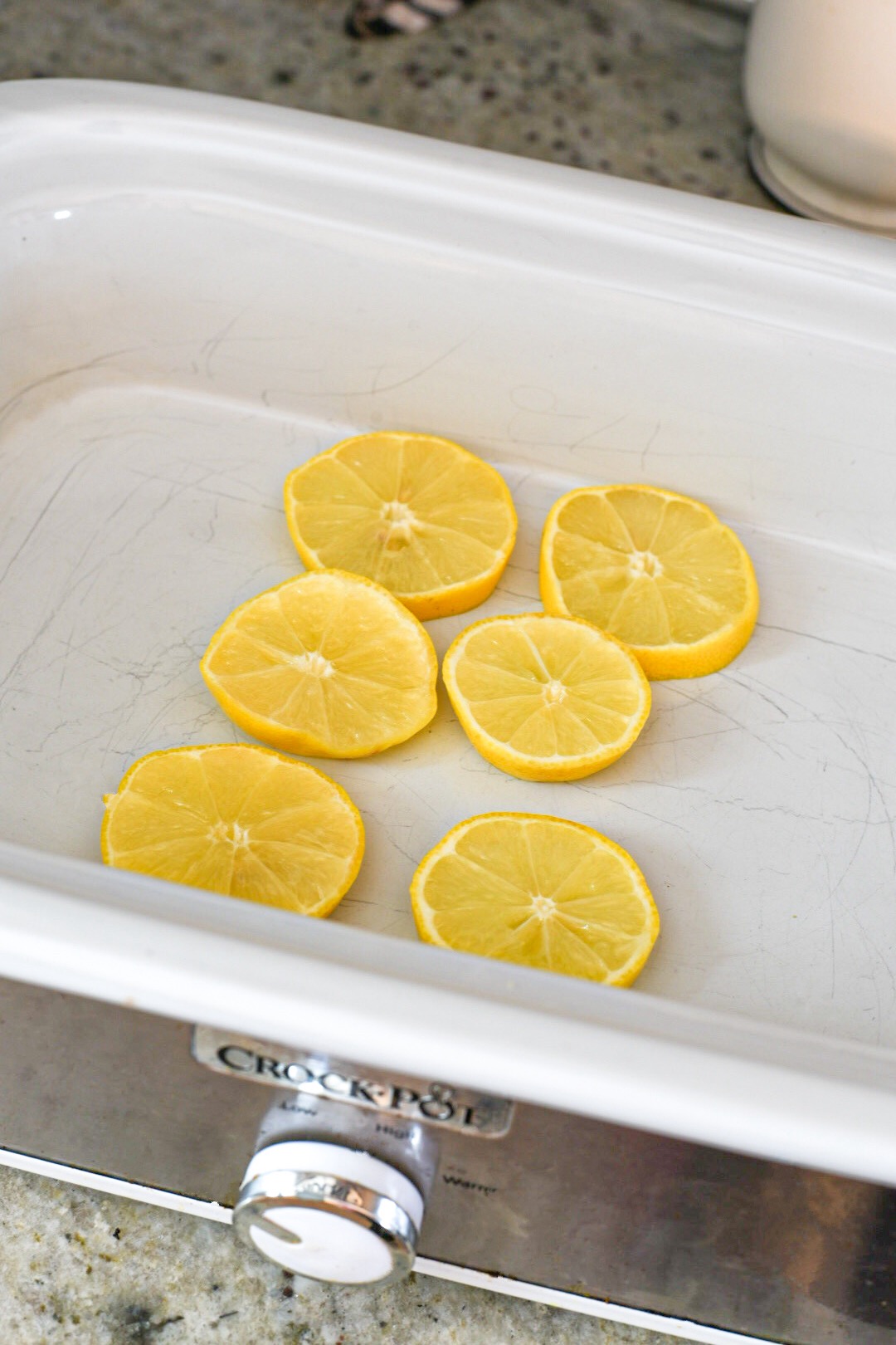 Six lemon slices in the bottom of a crock pot