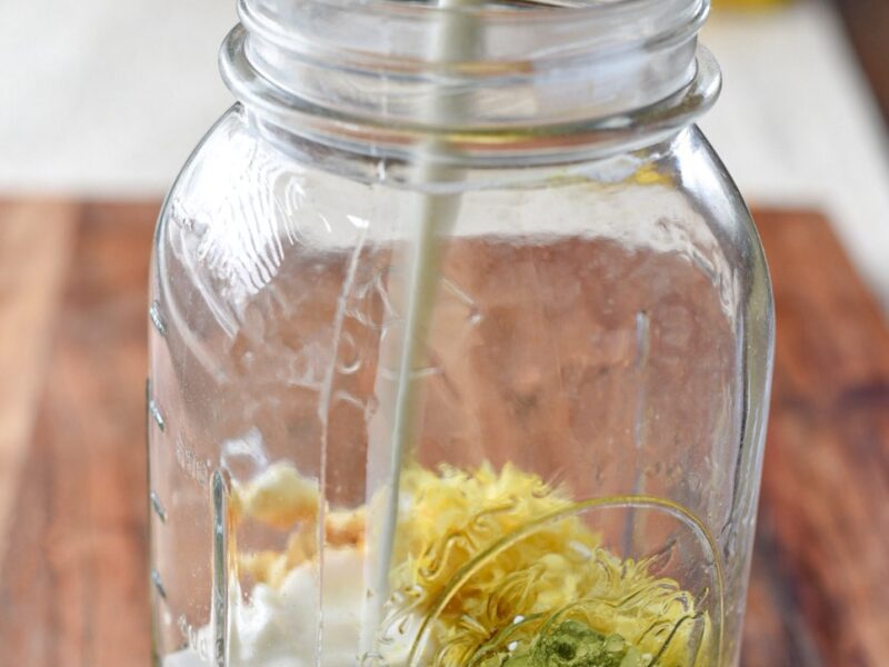A large glass mason jar filled with matcha overnight oats with milk being poured into the jar