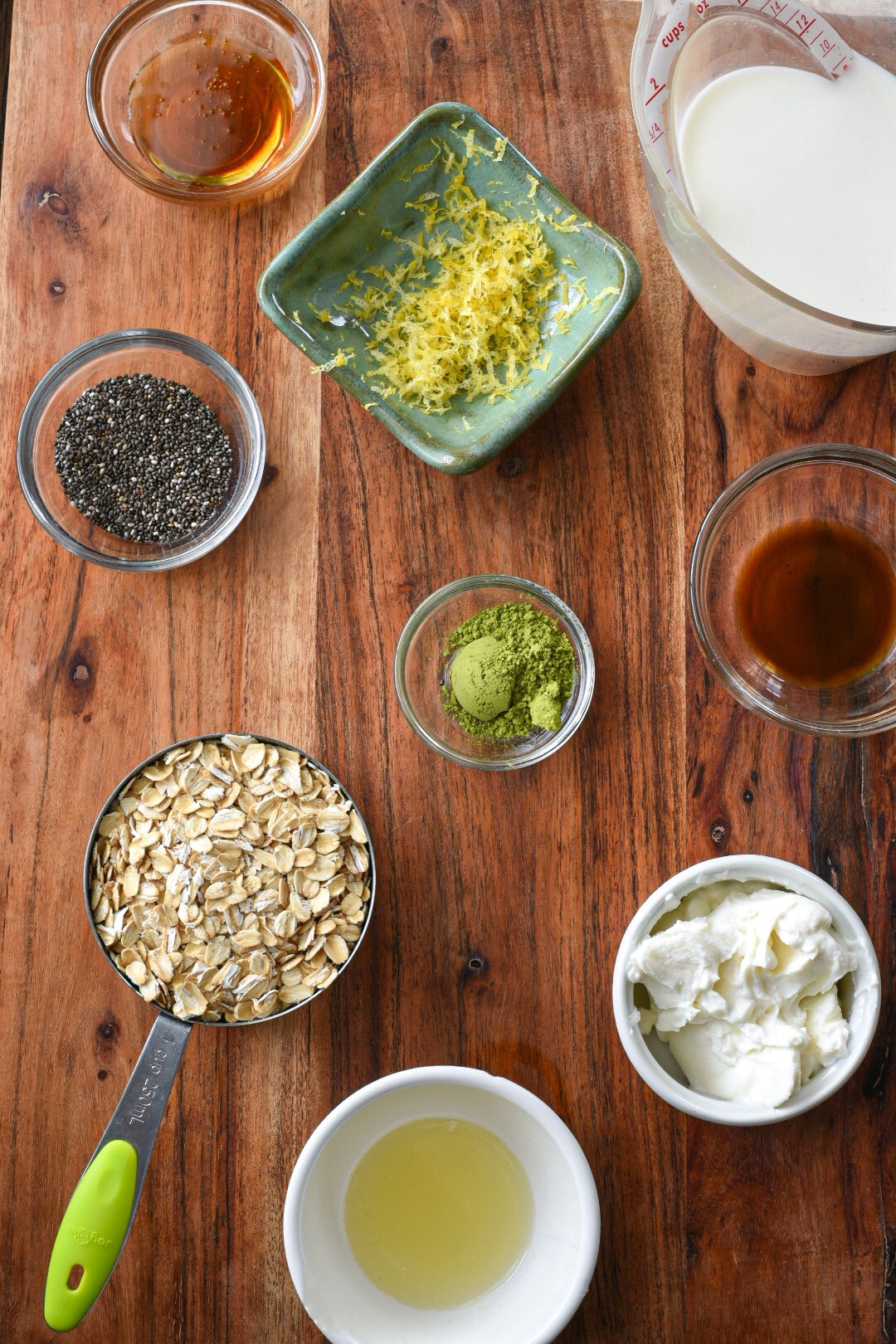 An overhead shot of the ingredients needed to make matcha overnight oats with lemon and honey