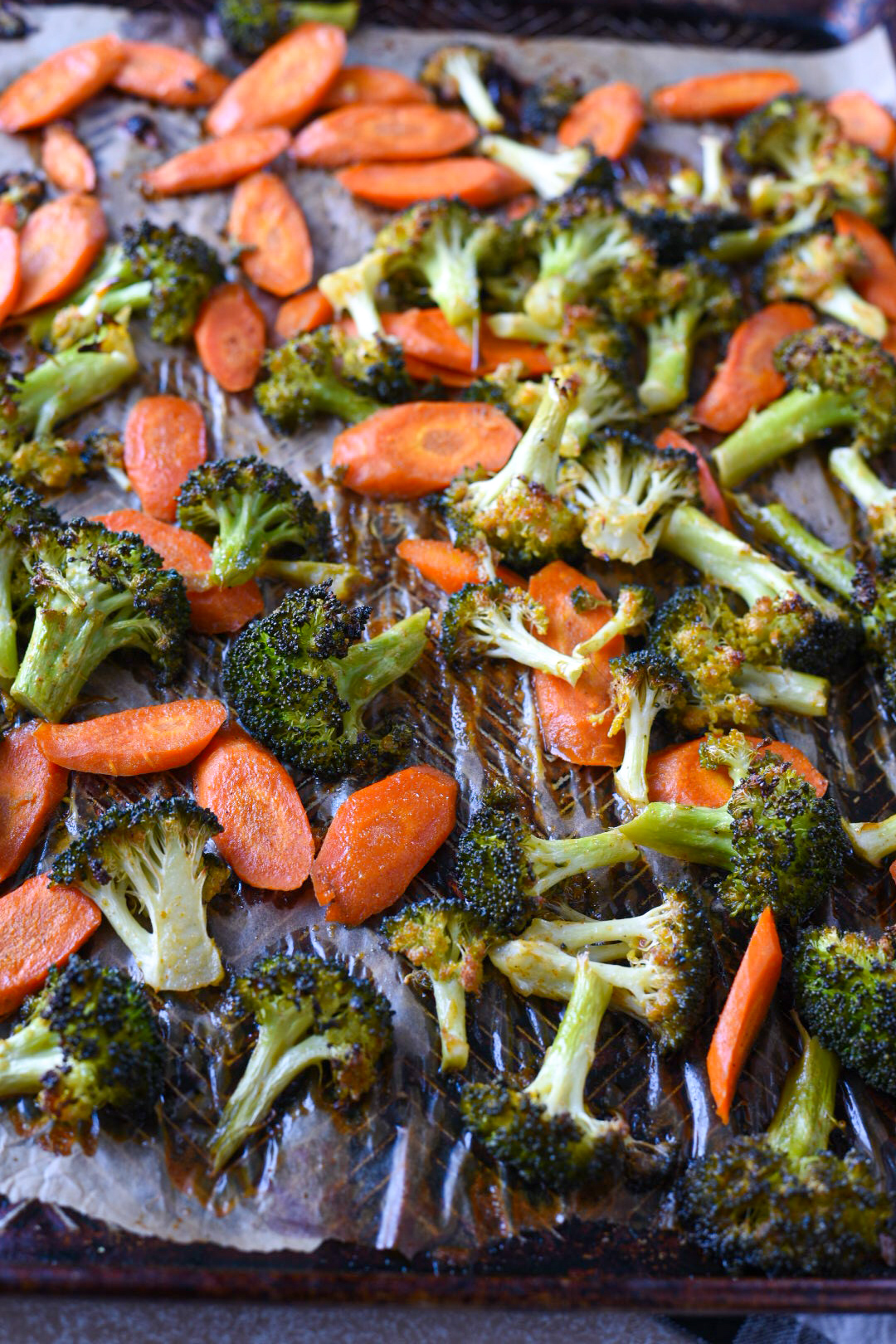 Roasted broccoli and carrots with honey dijon sauce on a baking sheet