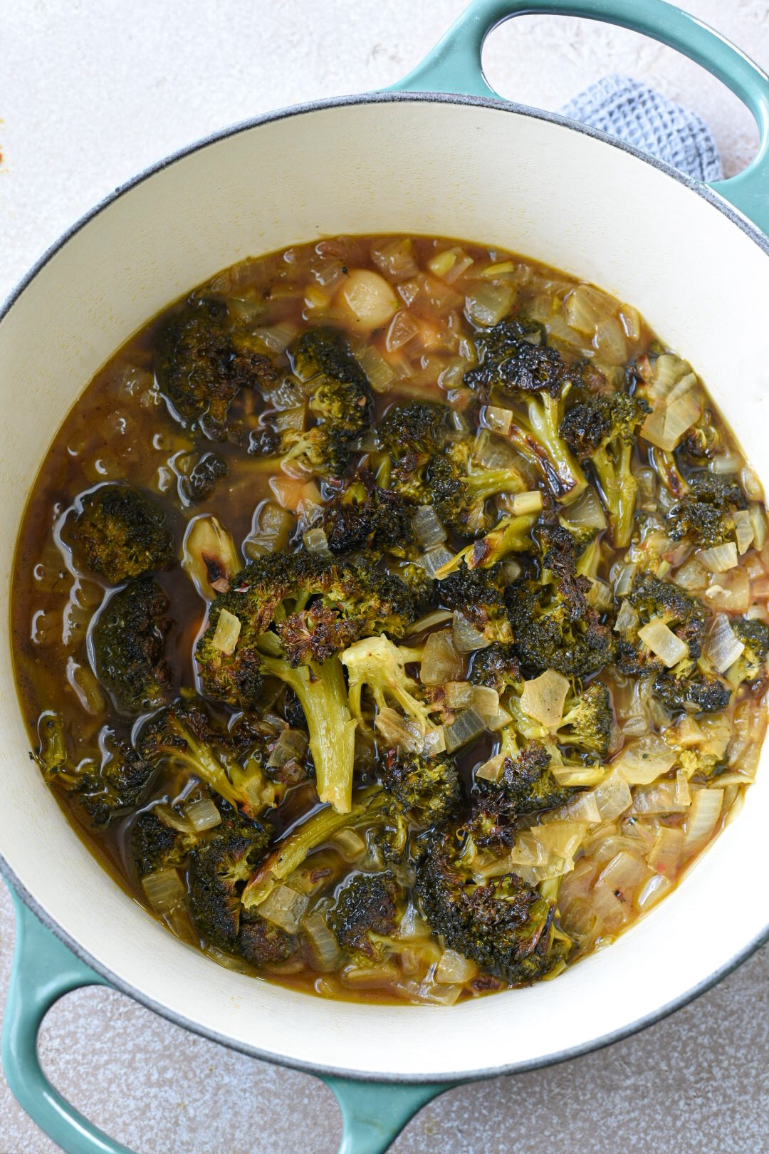 Broccoli feta soup with almonds boiling in a dutch oven