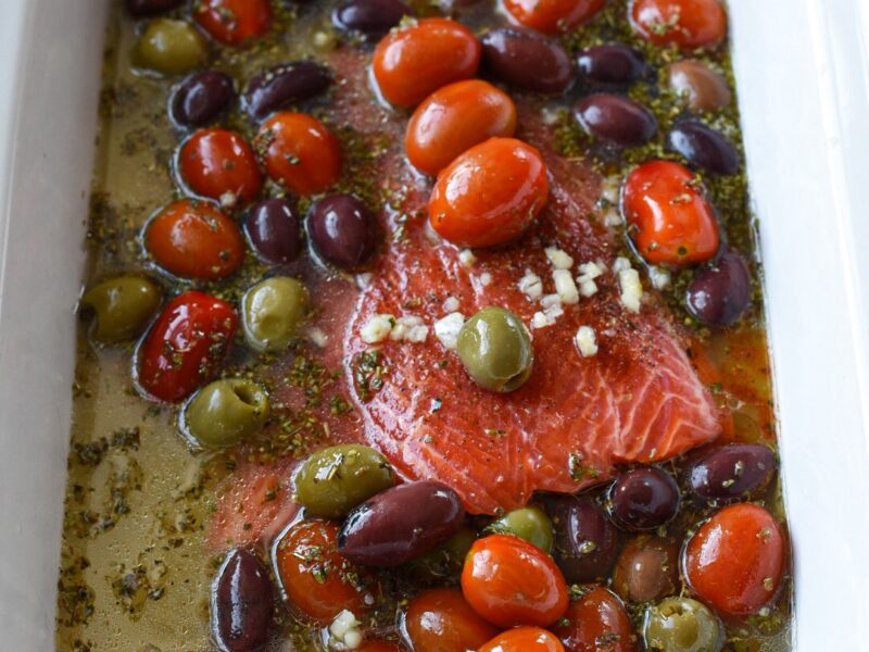 healthy slow cooker salmon recipe Raw salmon in a slow cooker with a lemon broth, olives and tomatoes
