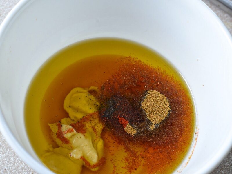 A white bowl filled with a honey mustard sauce for broccoli and carrots