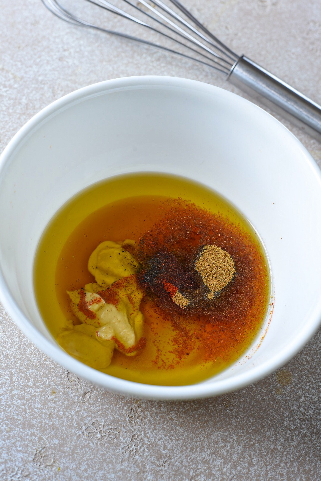 A white bowl filled with a honey mustard sauce for broccoli and carrots