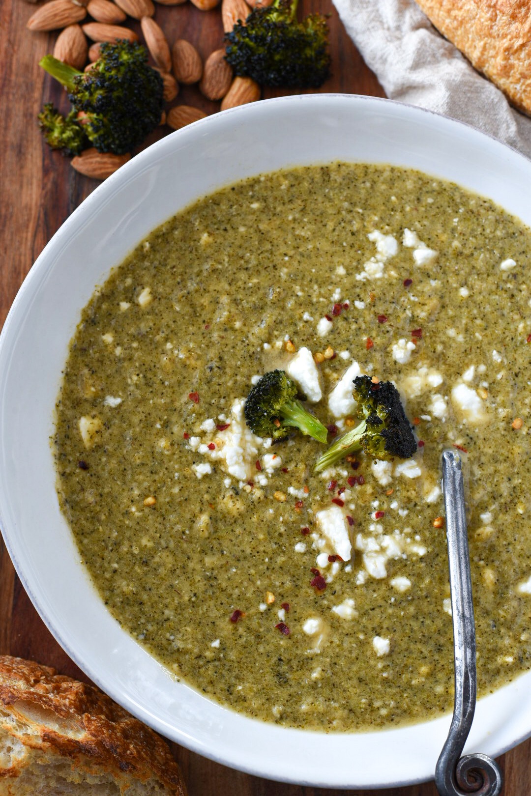 Broccoli feta soup sprinkled with feta and red pepper flakes in a white bowl