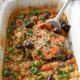 salmon in a slow cooker with olives, tomatoes and quinoa being lifted out by a spatula