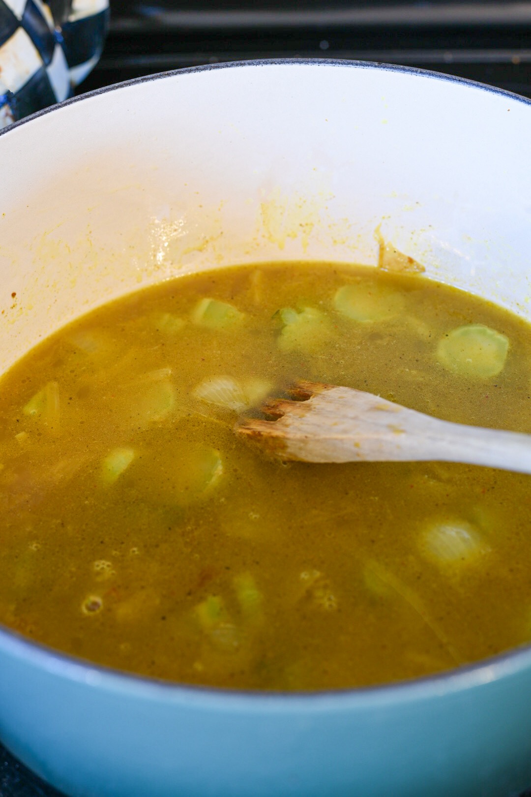 broccoli curry soup curried broccoli stem soup in a pot with a wooden spoon