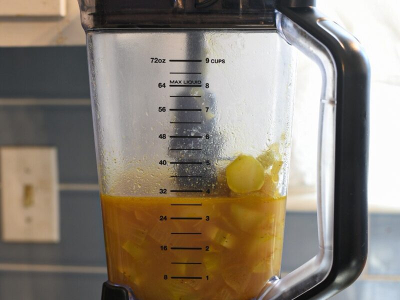 curried broccoli stem soup in a blender about to be blended.