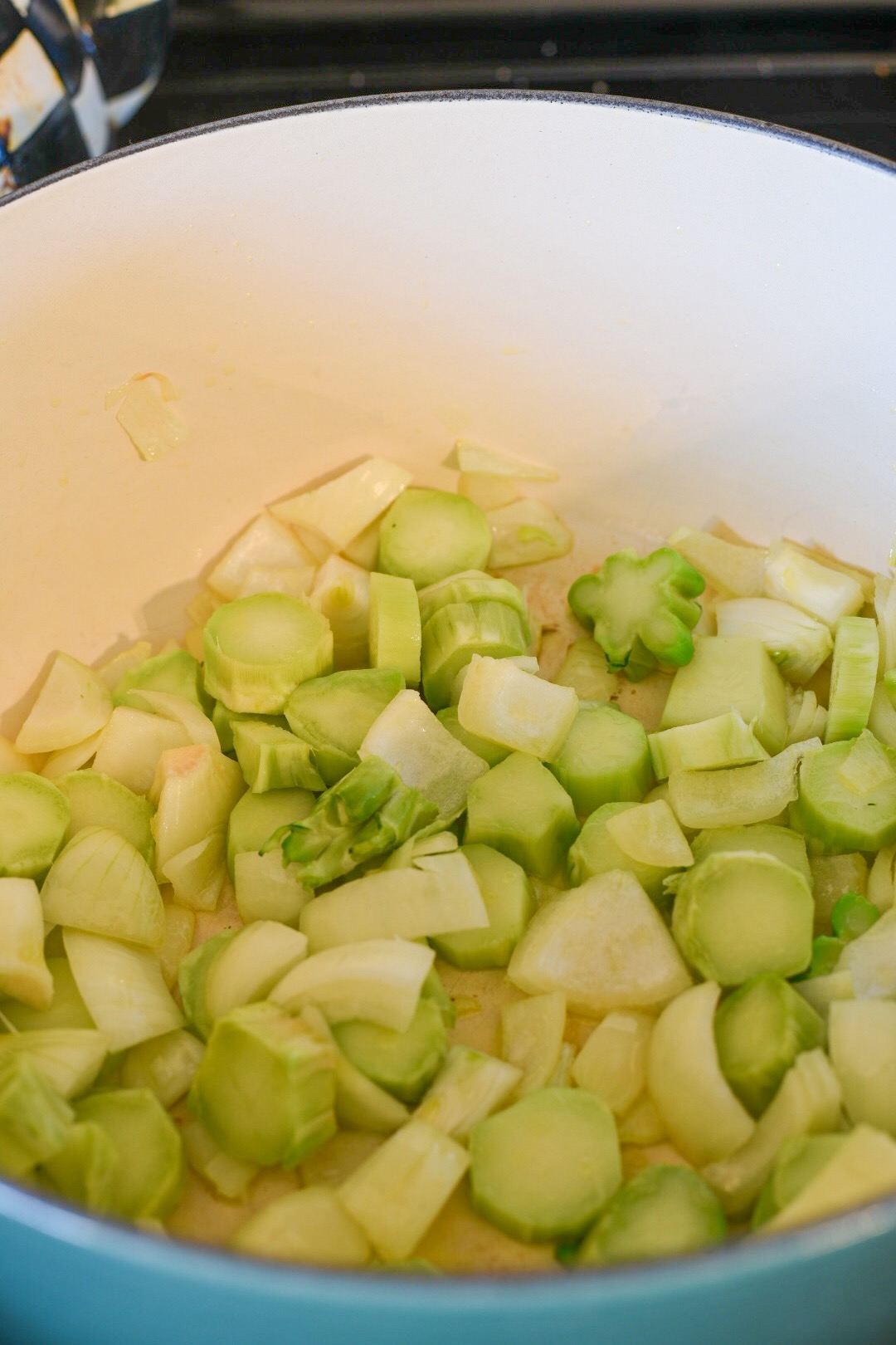 curried broccoli soup broccoli stems sauteing in a pot with onion for curried broccoli stem soup