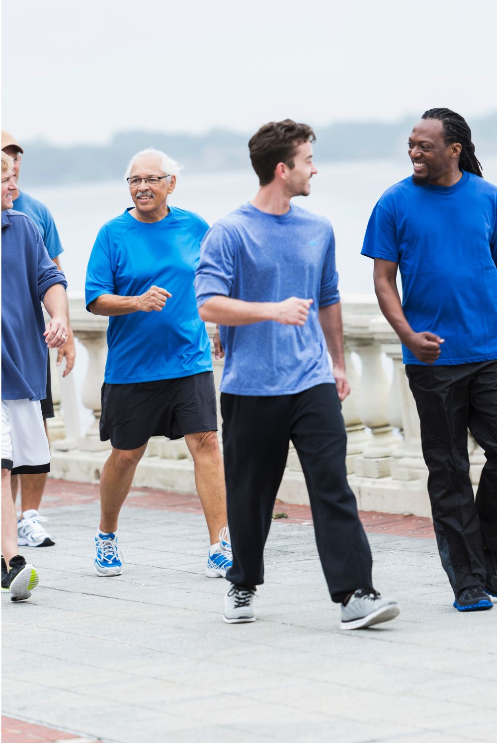 group of happy people walking A group of men walking together all wearing blue