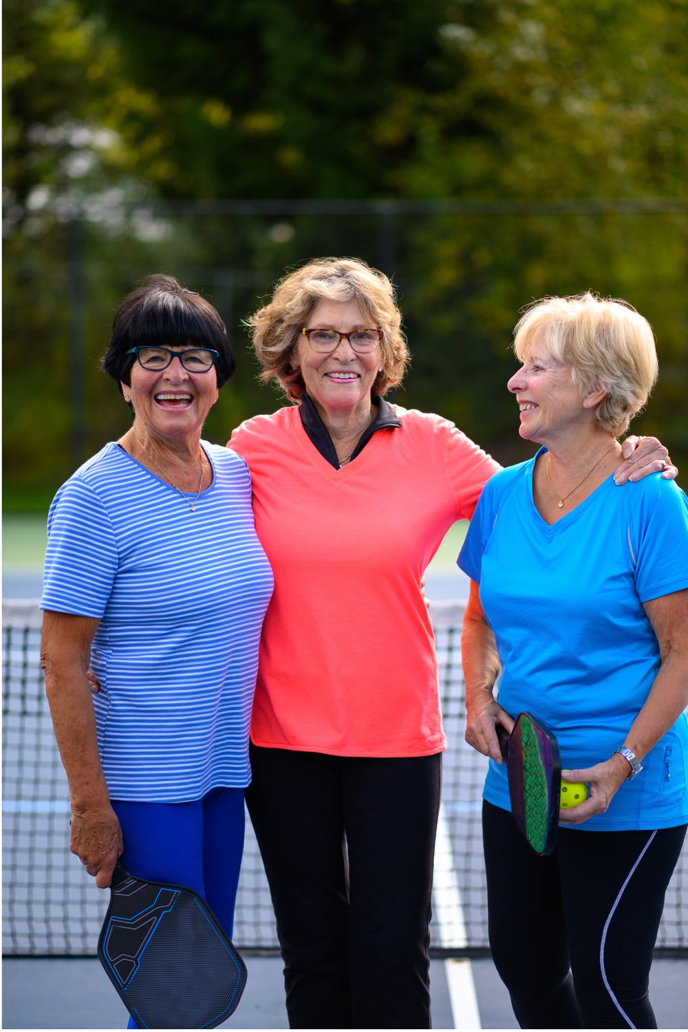 group of three friends (1) Three older ladies playing pickleball together and smiling