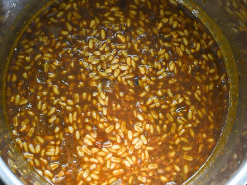 kamut side The inside of an instant pot with cooked kamut kernels in a dark brown gravy