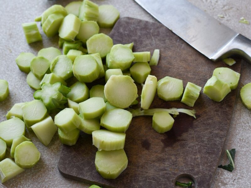 broccoli stem medallions chopped on a cutting board with a knife