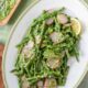 An overhead image of blanched asparagus salad with mint gremolata sauce on a white serving platter
