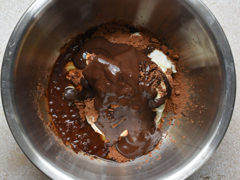 The ingredients for chocolate greek yogurt mousse in a metal mixing bowl