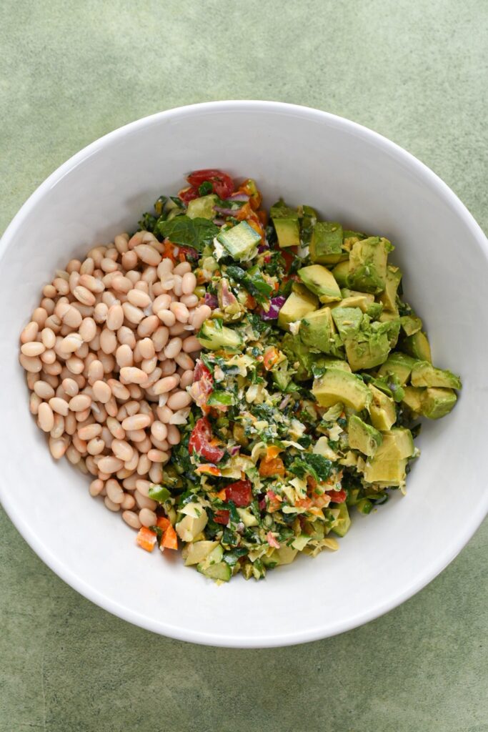 chopped mediterranean salad A white bowl filled with chopped Mediterranean salad, white beans and avocado before it was mixed