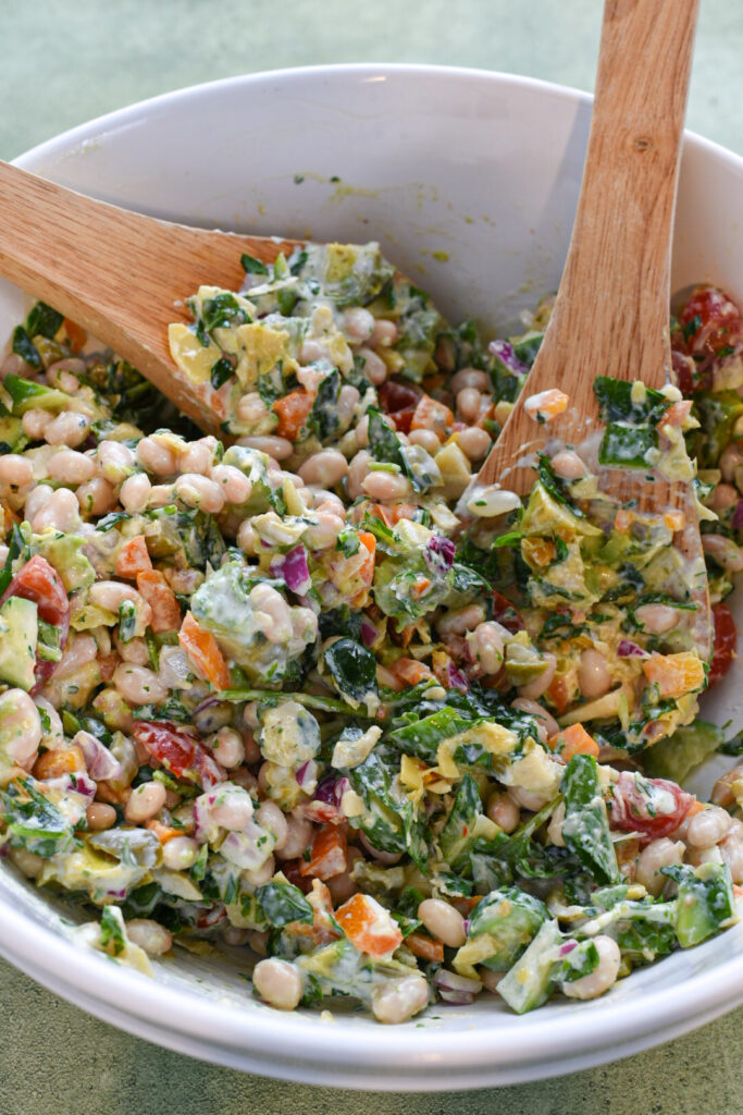 chopped salad in a bowl Mediterranean salad in a bowl mixed with avocado, beans and dressing