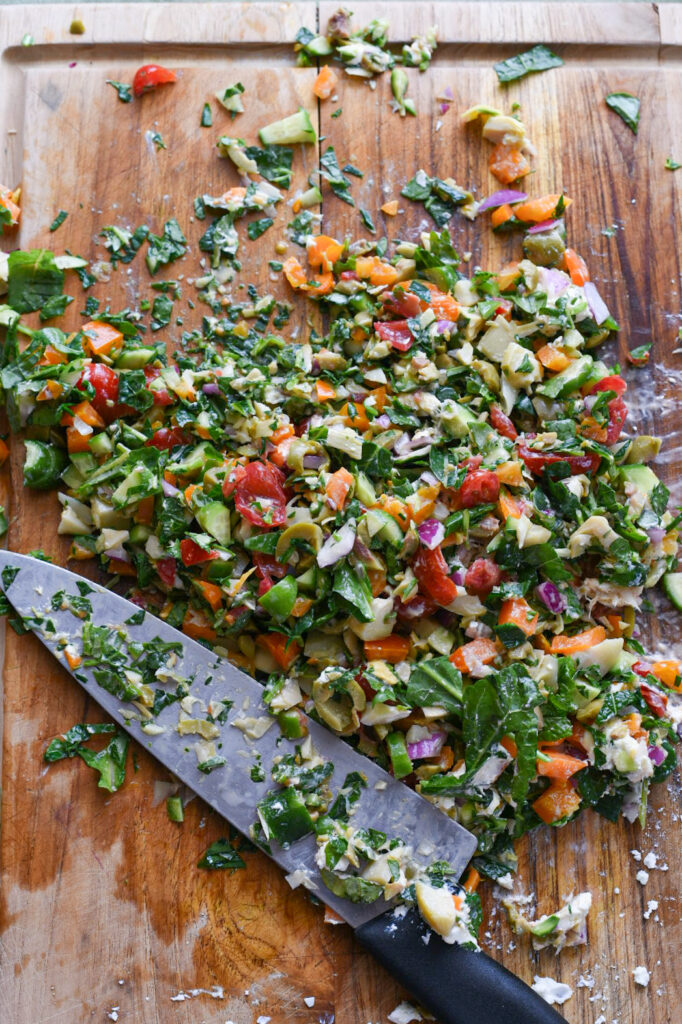 chopped salad recipe A copped Mediterranean salad on a cutting board after being chopped