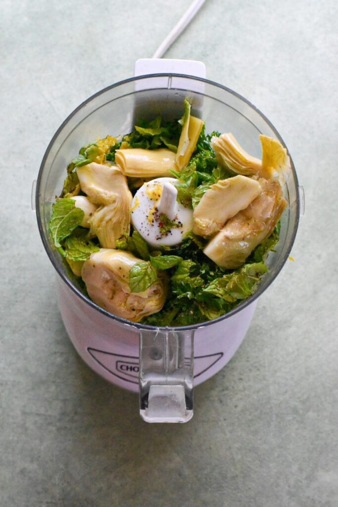 mint gremolata The ingredients for a mint gremolata sauce inside of a food processor with the lid off