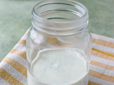 homemade ranch dressing with greek yogurt in a glass on a stripped towel