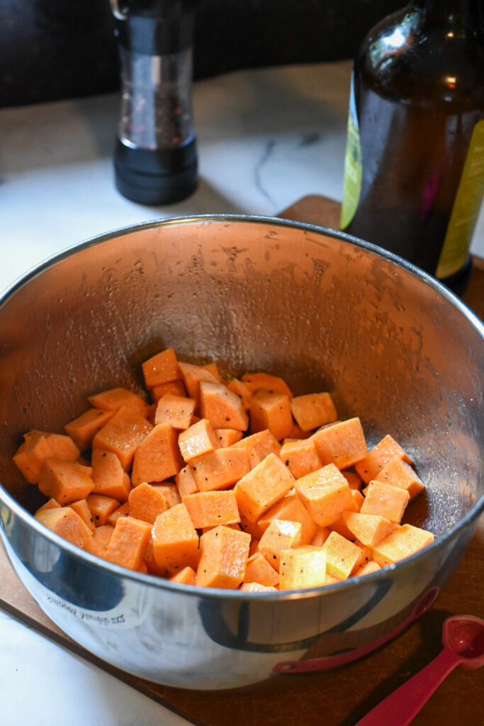 air fryer sweet potatoes Cubed sweet potato in a bowl tossed with olive oil and spices.