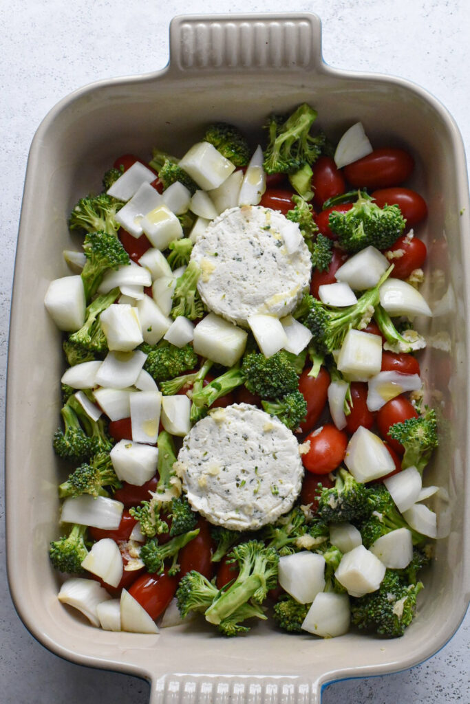 baked boursin cheese pasta recipes Two wheels of boursin cheese in a baking dish surrounded by cherry tomatoes, broccoli, and onion.