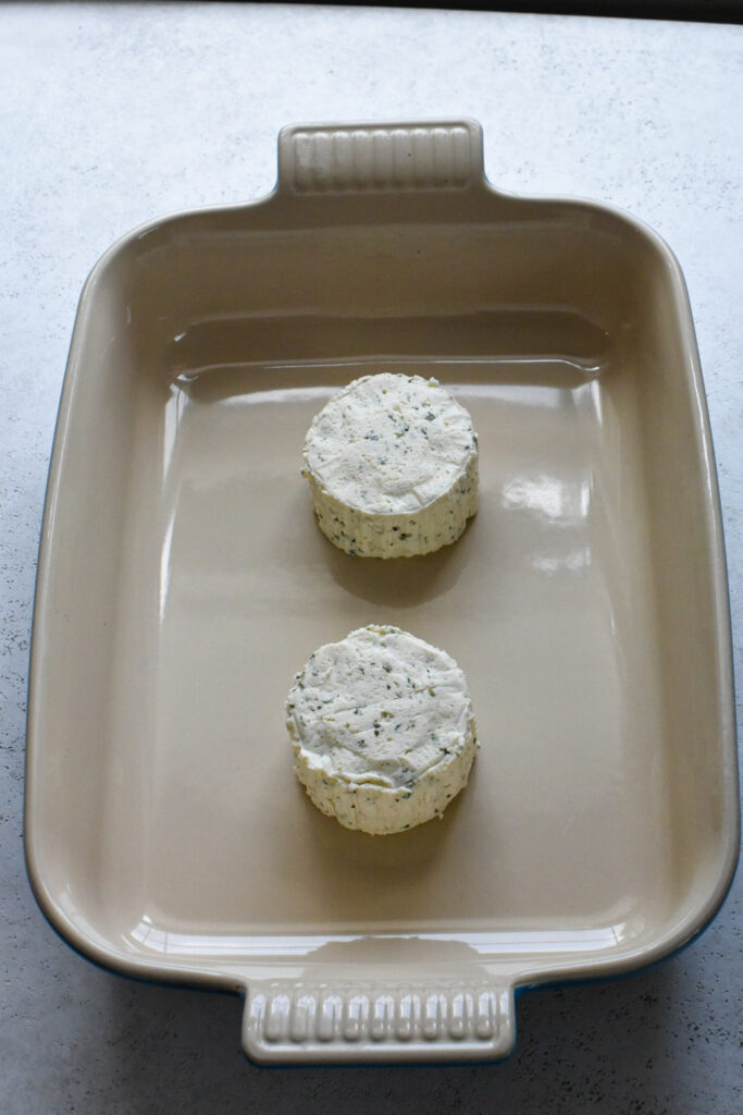 boursin cheese recipe with pasta Two wheels of boursin cheese in the bottom of a baking dish.