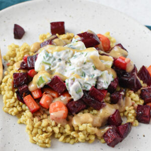 Roasted beets and carrots over barley topped with a tahini sauce and cucumber yogurt.