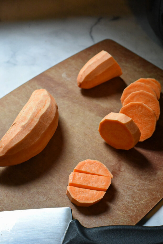 cubed sweet potatoes Sweet potato medallions cut into strips on a cutting board.